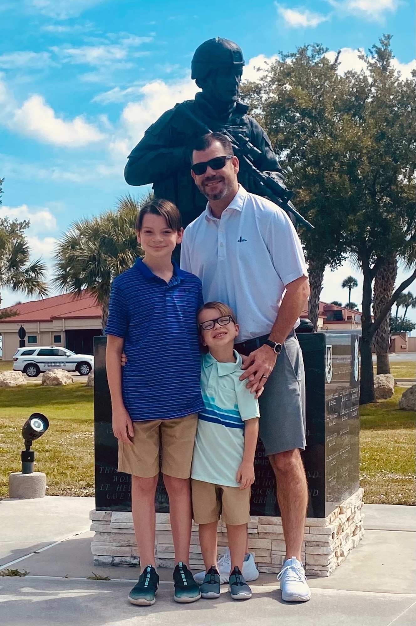Tripp, Lennon, and John Little pose for a photo in front of the memorial to U.S. Air Force 1st Lt. Joseph Helton on MacDill AFB, April 30, 2022. Helton was killed in action in Iraq, Sept. 8, 2009. (Courtesy photo)