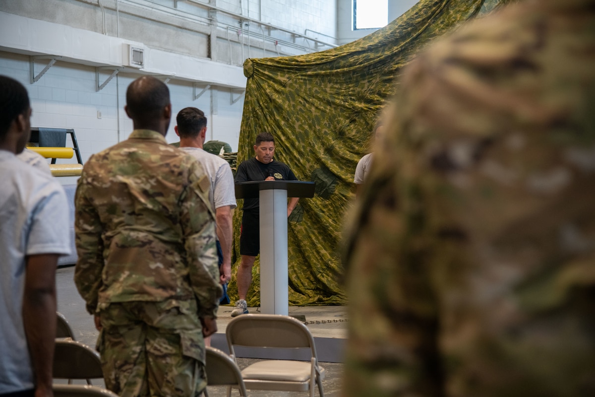 Airmen stand at attention as Col. Trujillo speaks from behind a podium