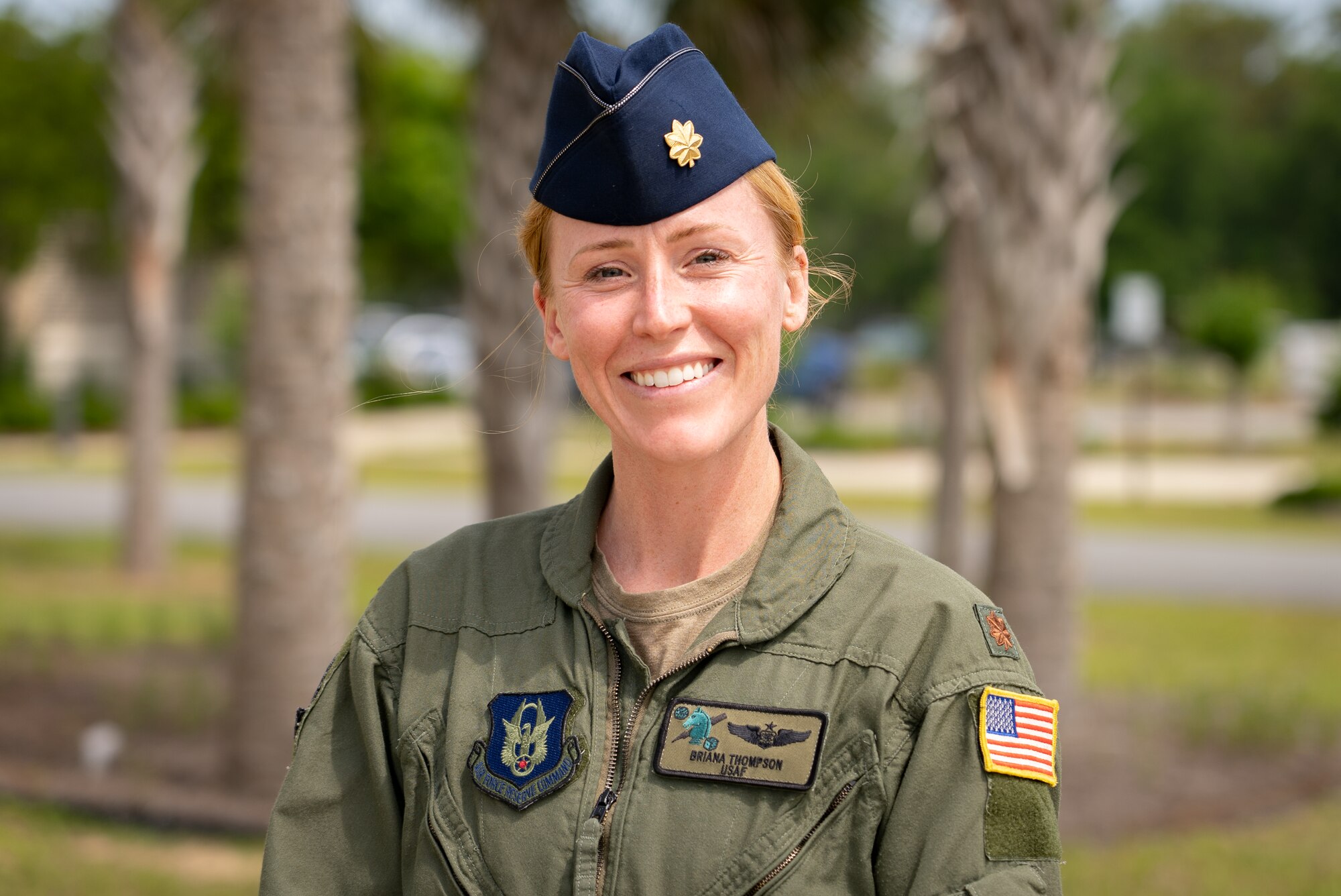 Female Airman in flight suit poses for photo.