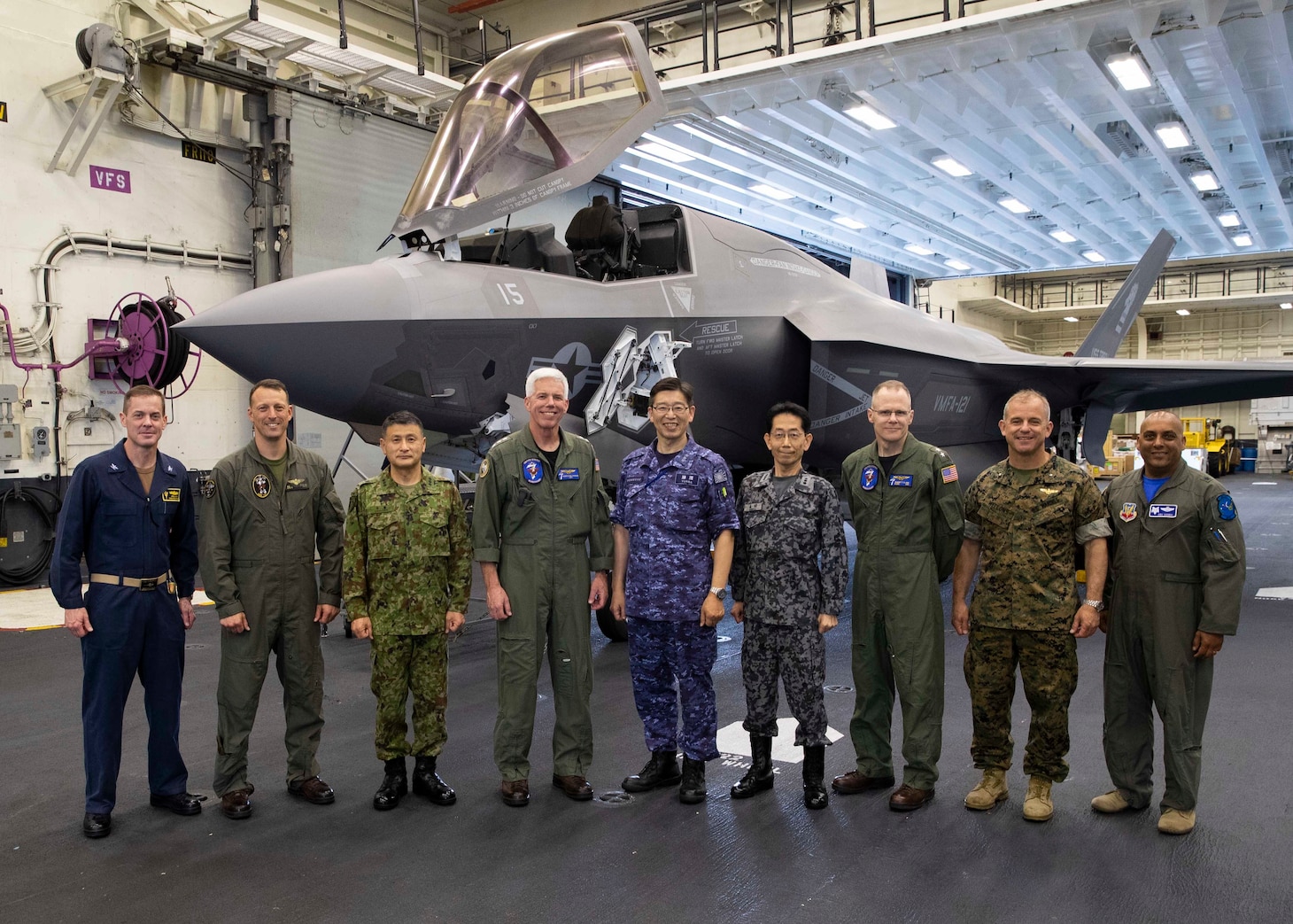 220603-N-TT639-1073 PACIFIC OCEAN (June 3, 2022) – Vice Adm. Hideki Yuasa, commander in chief, Self-Defense Fleet, center, Vice Adm. Karl Thomas commander, U.S. 7th Fleet, left of center, members of the Japanese Self Defense Force and U.S. Navy, Marine Corps, and Air Force pose for a photo during a tour aboard amphibious assault carrier USS Tripoli (LHA 7), June 3, 2022. Tripoli is operating in the U.S. 7th Fleet area of operations to enhance interoperability with allies and partners and serve as a ready response force to defend peace and maintain stability in the Indo-Pacific region.  (U.S. Navy photo by Mass Communication Specialist 3rd Class Christopher Sypert)