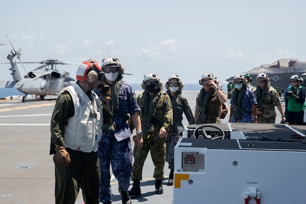 220603-N-XN177-1159 PACIFIC OCEAN (June 3, 2022) – Members of Japan Self-Defense Force walk across the flight deck aboard amphibious assault carrier USS Tripoli (LHA 7), June 3, 2022. Tripoli is conducting routine operations in U.S. 7th Fleet. (U.S. Navy photo by Mass Communication Specialist 1st Class Peter Burghart)