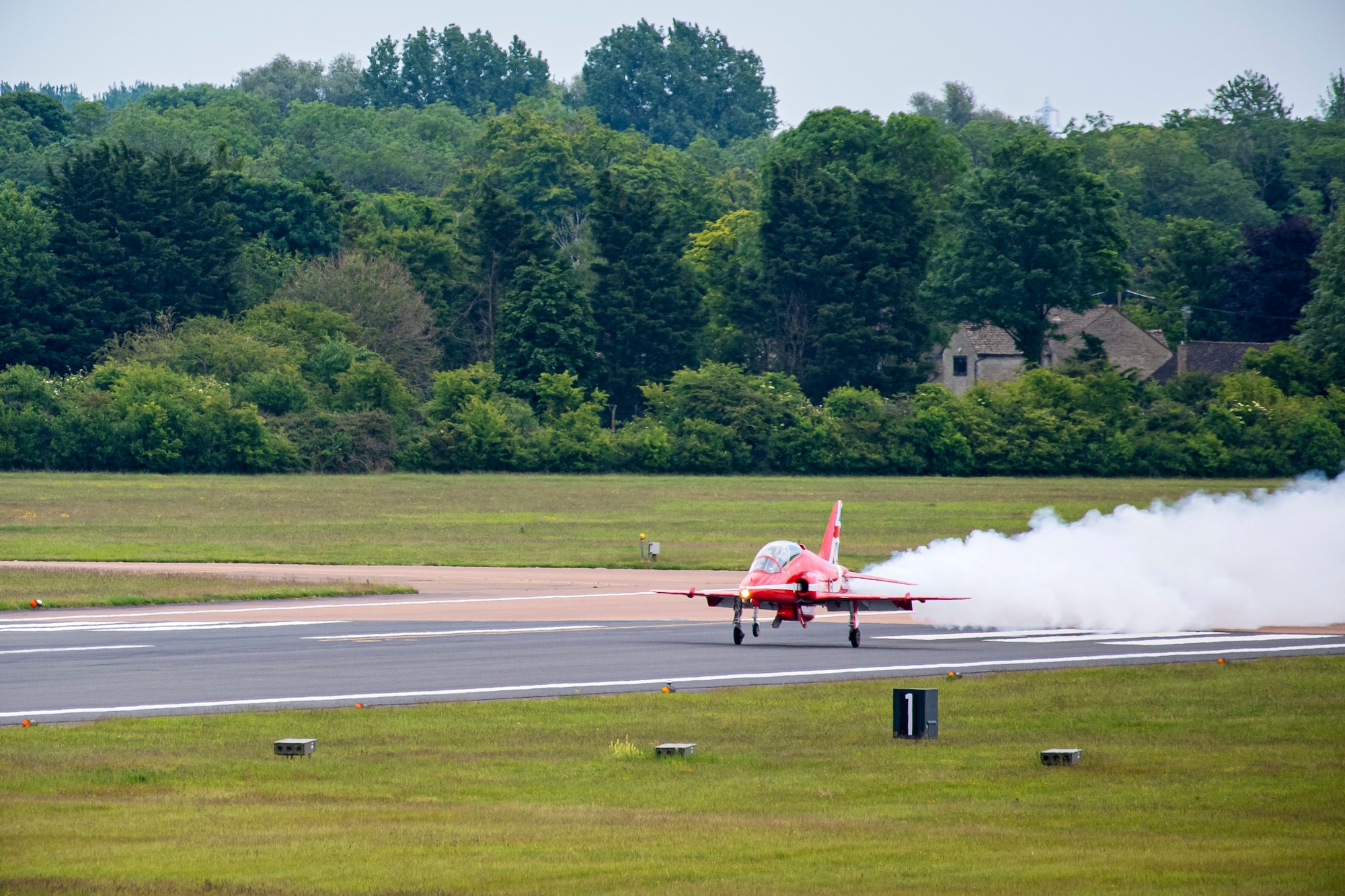 A Hawk T1 aircraft assigned to the Royal Air Force aerobatic team, known as the Red Arrows, lands on the runway at RAF Fairford, England, June 2, 2022. The Red Arrows landed at Fairford to refuel in preparation for the Queen’s Platinum Jubilee Ceremonies and Midlands Air Festival. (U.S. Air Force photo by Staff Sgt. Eugene Oliver)