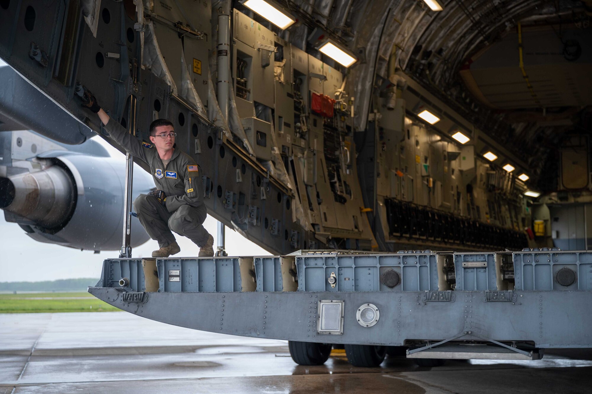 Senior Airman Kolton Sittig, 3rd Airlift Squadron loadmaster, awaits cargo during a local training mission at Dover Air Force Base, Delaware, May 24, 2022. The 3rd AS regularly trains to provide global reach and support global engagement with time-critical theater assets. (U.S. Air Force photo by Senior Airman Faith Schaefer)
