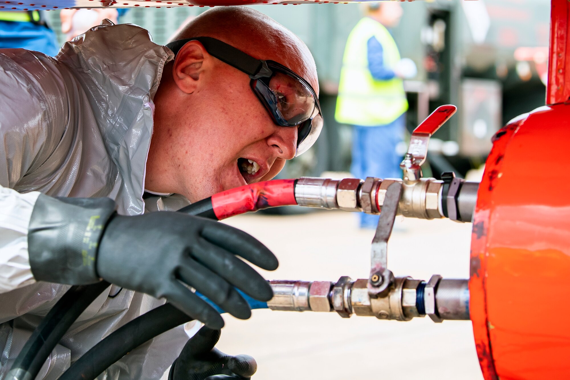 A Royal Air Force Red Arrows dye team member refuels the dye canisters on a Hawk T1 aircraft at RAF Fairford, England, June 2, 2022. The Red Arrows landed at Fairford to refuel in preparation for the Queen’s Platinum Jubilee Ceremonies and Midlands Air Festival. (U.S. Air Force photo by Staff Sgt. Eugene Oliver)