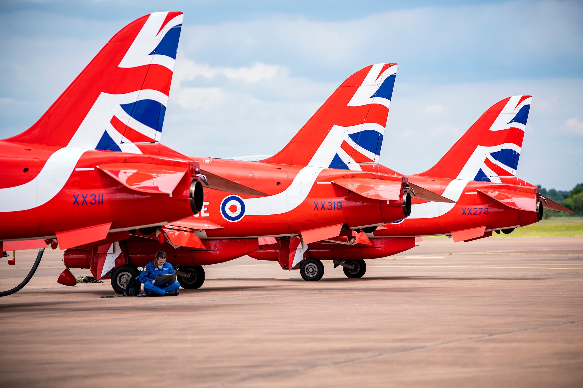 A member of the Royal Air Force aerobatic team, known as the Red Arrows, works on a laptop at RAF Fairford, England, June 2, 2022. The Red Arrows landed at Fairford to refuel in preparation for the Queen’s Platinum Jubilee Ceremonies and Midlands Air Festival. (U.S. Air Force photo by Staff Sgt. Eugene Oliver)