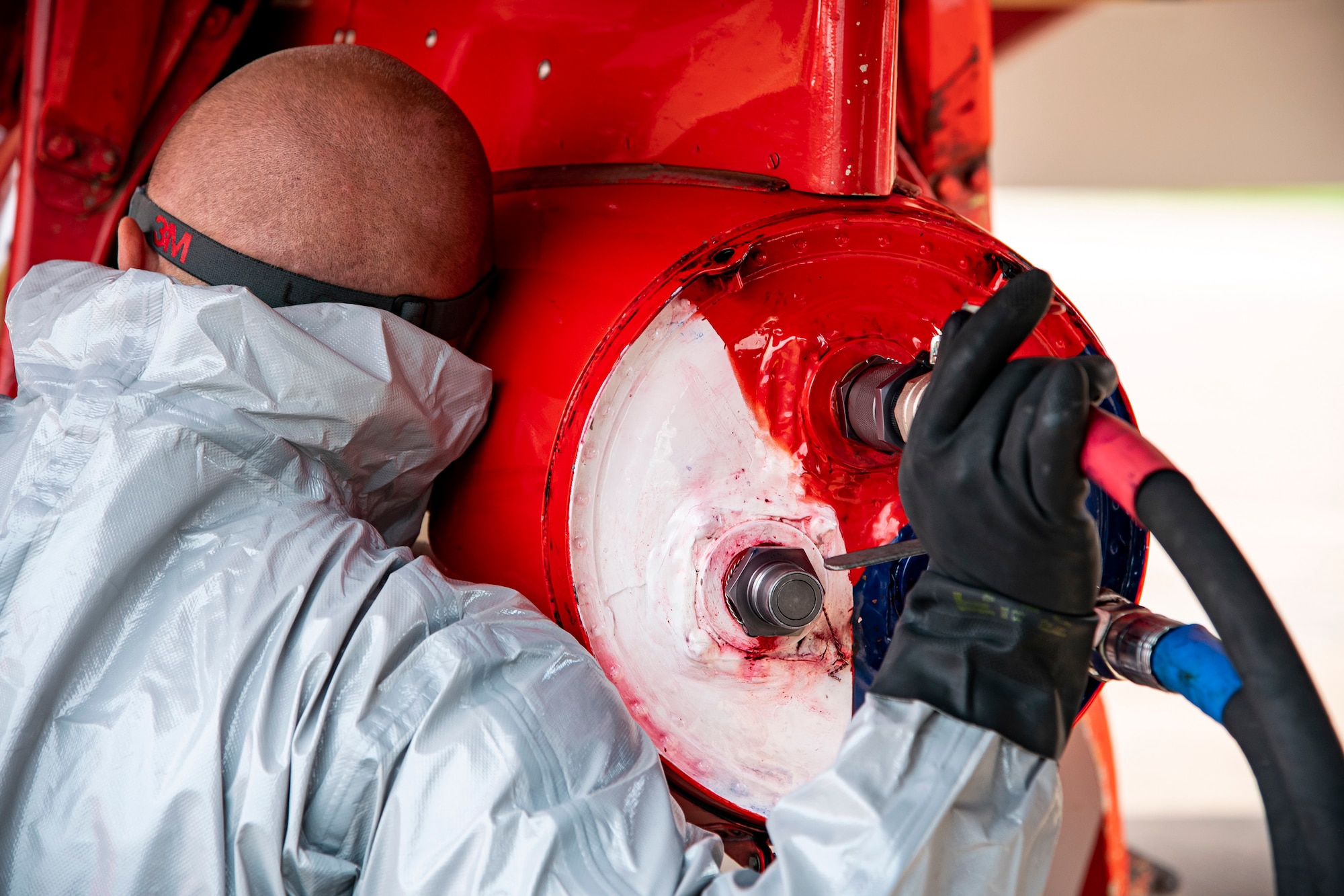 A Royal Air Force Red Arrows dye team member refuels the dye canisters on a Hawk T1 aircraft at RAF Fairford, England, June 2, 2022. The Red Arrows landed at Fairford to refuel in preparation for the Queen’s Platinum Jubilee Ceremonies and Midlands Air Festival. (U.S. Air Force photo by Staff Sgt. Eugene Oliver)