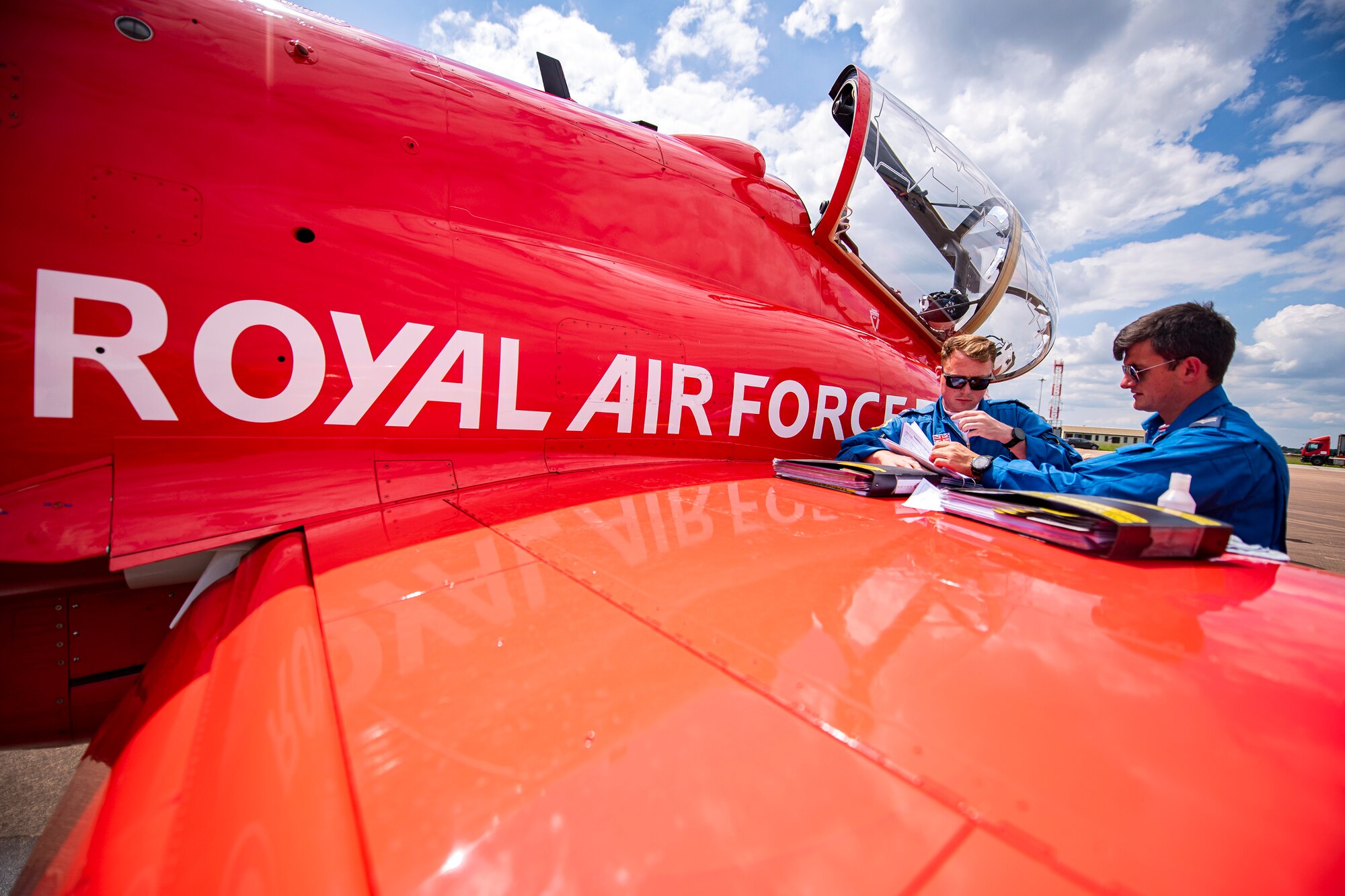 Royal Air Force Corporals Nicholas Sabin, left, and Colin Macdonald, Red Arrows engineering technicians, read flight plans at RAF Fairford, England, June 2, 2022. The Red Arrows landed at Fairford to refuel in preparation for the Queen’s Platinum Jubilee Ceremonies and Midlands Air Festival. (U.S. Air Force photo by Staff Sgt. Eugene Oliver)