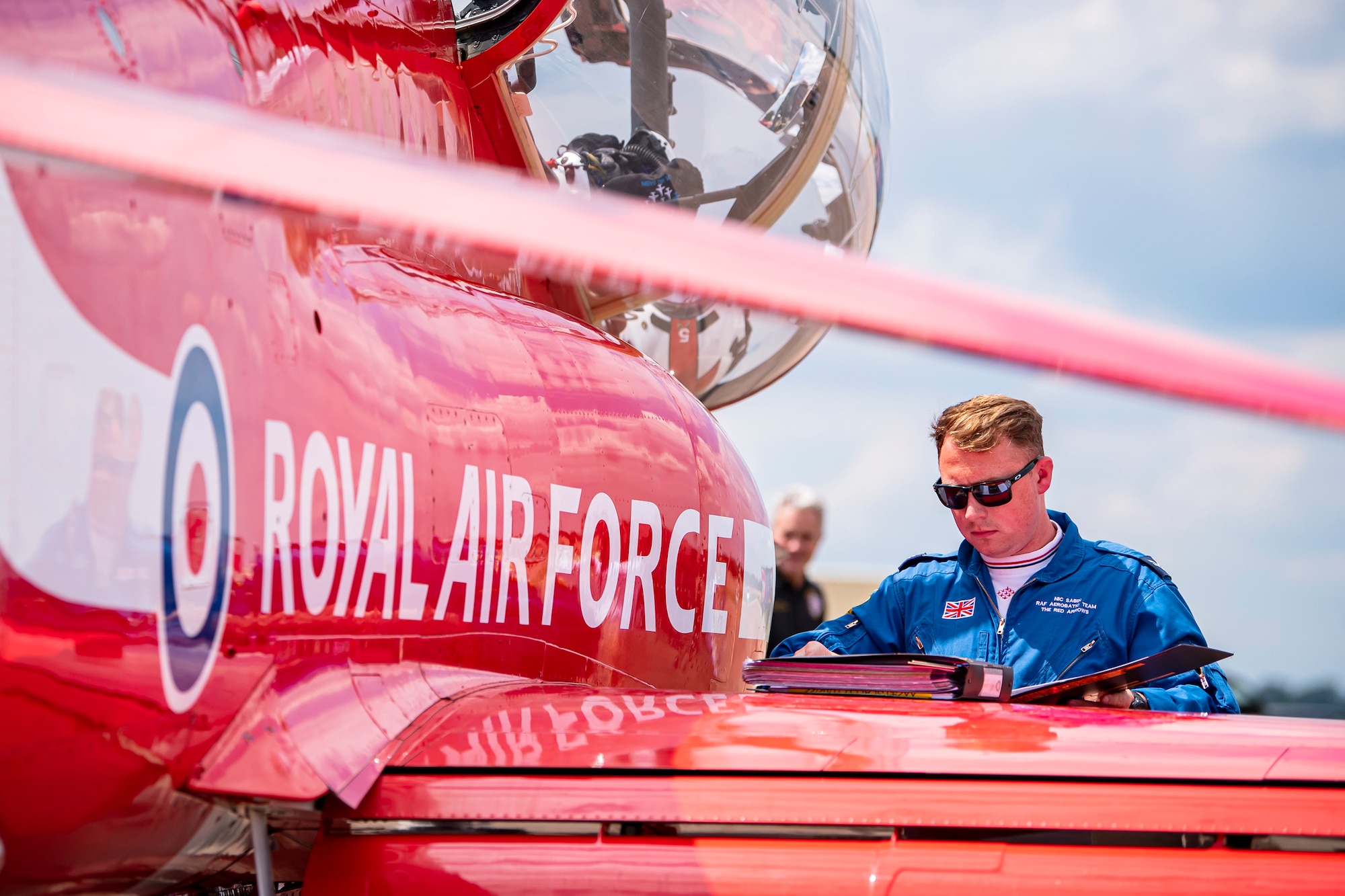 Royal Air Force Corporal Nicholas Sabin, Red Arrows engineering technician, reads a flight plan at RAF Fairford, England, June 2, 2022. The Red Arrows landed at Fairford to refuel in preparation for the Queen’s Platinum Jubilee Ceremonies and Midlands Air Festival. (U.S. Air Force photo by Staff Sgt. Eugene Oliver)