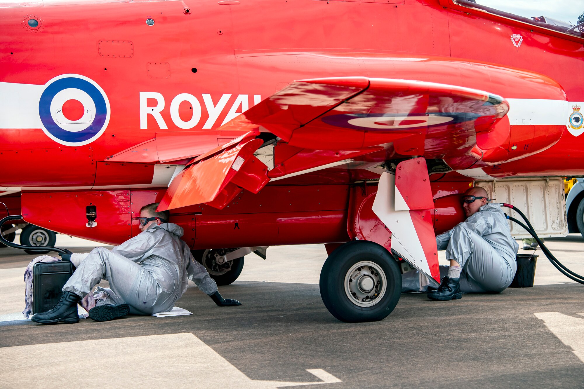 Royal Air Force Red Arrows dye team members refuel the dye canisters on a Hawk T1 aircraft at RAF Fairford, England, June 2, 2022. The Red Arrows landed at Fairford to refuel in preparation for the Queen’s Platinum Jubilee Ceremonies and Midlands Air Festival. (U.S. Air Force photo by Staff Sgt. Eugene Oliver)