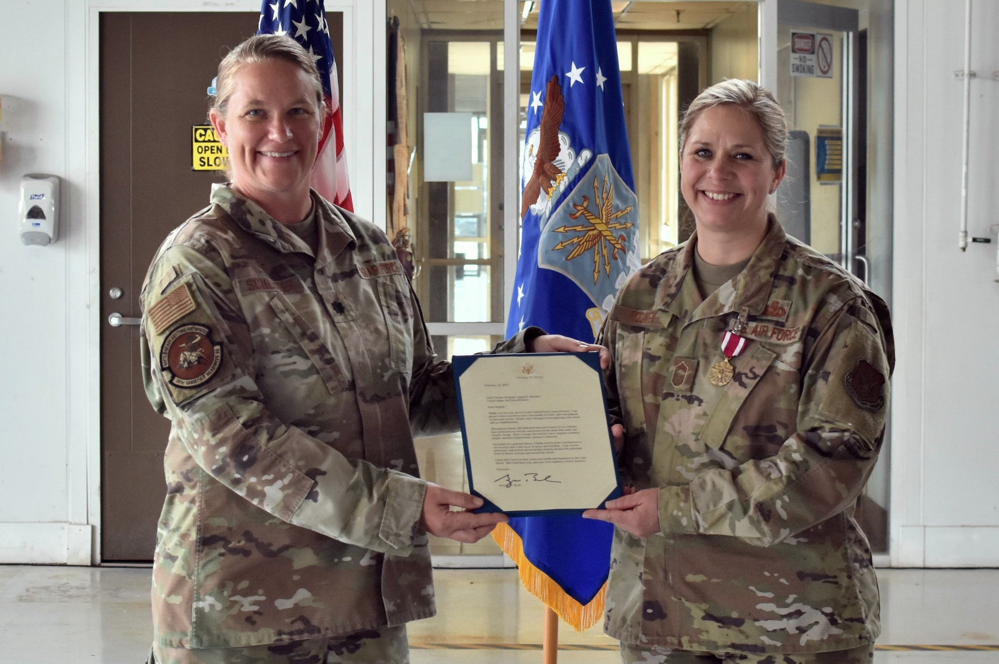 Lt. Col. Farrah Schluter, 301st Fighter Wing Logistics Readiness Squadron commander, and Chief Master Sgt. Angela Rooney, 301 FW LRS senior enlisted leader, hold Rooney’s certificate of appreciation signed by former U.S. President, George W. Bush at Naval Air Station Joint Reserve Base Fort Worth, Texas on June 4, 2022. President Bush thanked Rooney for her 25 years of military service. (U.S. Air Force photo by Staff Sgt. Randall Moose)