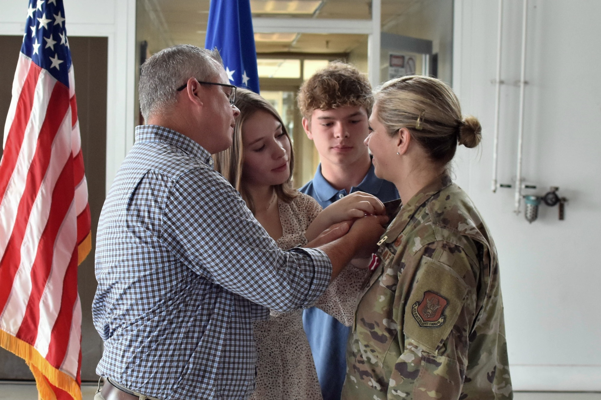 Chief Master Sgt. Angela Rooney’s, 301st Logistics Readiness Squadron senior enlisted leader, family places the retirement pin on Rooney’s uniform at Naval Air Station Joint Reserve Base Fort Worth, Texas on June 4, 2022. This retirement pin commemorates Rooney’s service in the U.S. Air Force. (U.S. Air Force photo by Staff Sgt. Randall Moose)