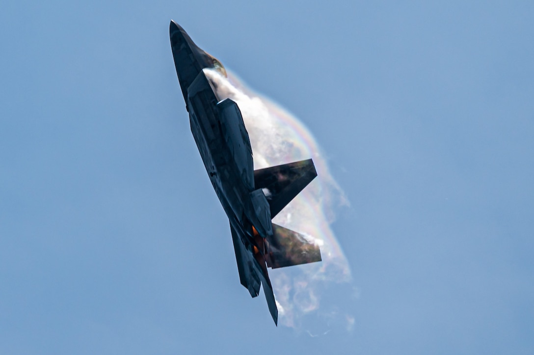 A fighter jet flies upward.