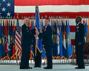 Col. Christopher Menuey, former 91st Missile Wing commander, hands off the guidon to Maj. Gen. Michael Lutton, 20th Air Force commander, at Minot Air Force Base, North Dakota, June 06, 2022. The primary focus of change of command ceremonies is to allow Airmen to witness the formality of command change from one officer to another. (U.S. Air Force photo by Airman 1st Class Evan Lichtenhan)