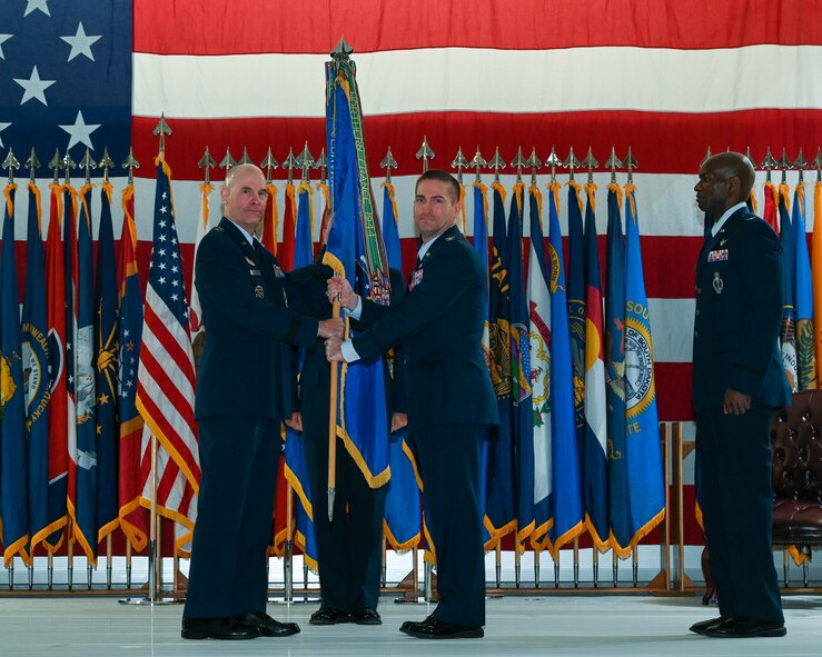 Col. Christopher Menuey, former 91st Missile Wing commander, hands off the guidon to Maj. Gen. Michael Lutton, 20th Air Force commander, at Minot Air Force Base, North Dakota, June 06, 2022. The primary focus of change of command ceremonies is to allow Airmen to witness the formality of command change from one officer to another. (U.S. Air Force photo by Airman 1st Class Evan Lichtenhan)