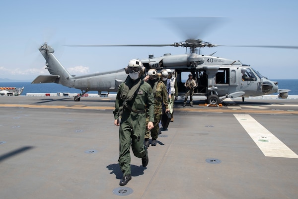 220603-N-XN177-1178 PACIFIC OCEAN (June 3, 2022) – Members of Japan Self-Defense Force disembark an MH-60S Sea Hawk helicopter assigned to Helicopter Sea Combat Squadron (HSC) 23 on the flight deck aboard amphibious assault carrier USS Tripoli (LHA 7), June 3, 2022. Tripoli is conducting routine operations in U.S. 7th Fleet. (U.S. Navy photo by Mass Communication Specialist 1st Class Peter Burghart)