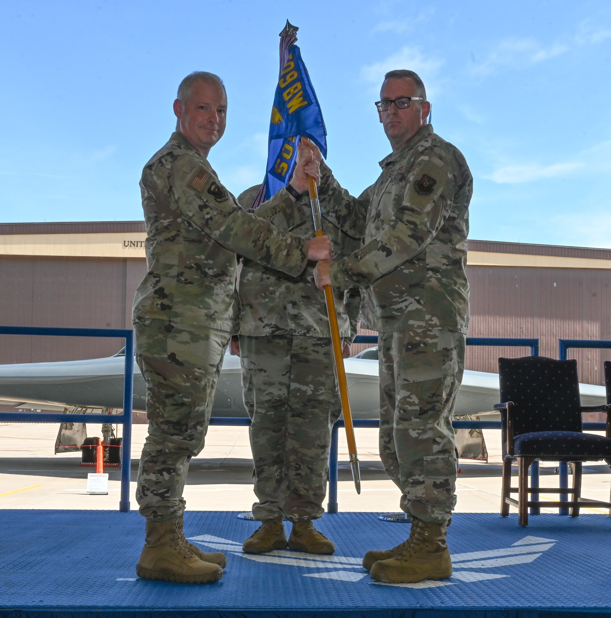 U.S. Air Force Col. Bruce T. Guest assumes command of the 509th Maintenance Group and receives the ceremonial guidon from U.S. Air Force Col. Daniel Diehl, 509th Bomb Wing commander, at Whiteman Air Force Base, Missouri, June 6, 2022. The 509th MXG provides full spectrum organizational and field-level maintenance and munitions support for the 509th Bomb Wing. (U.S. Air Force photo by Airman 1st Class Bryson Britt)