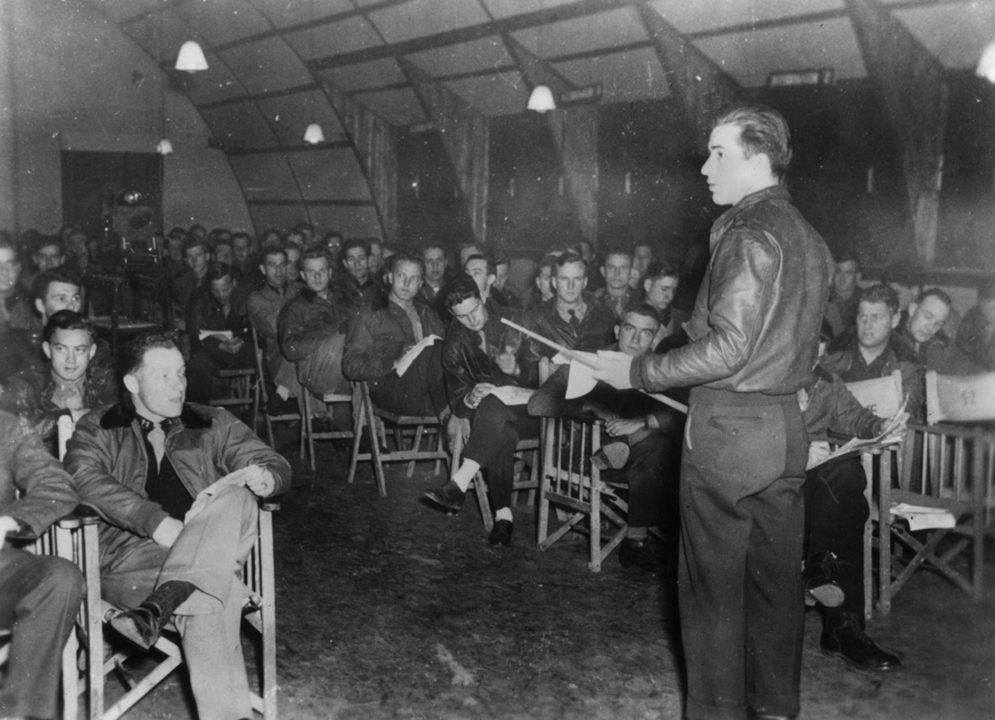 A photo of pilots receiving a briefing.