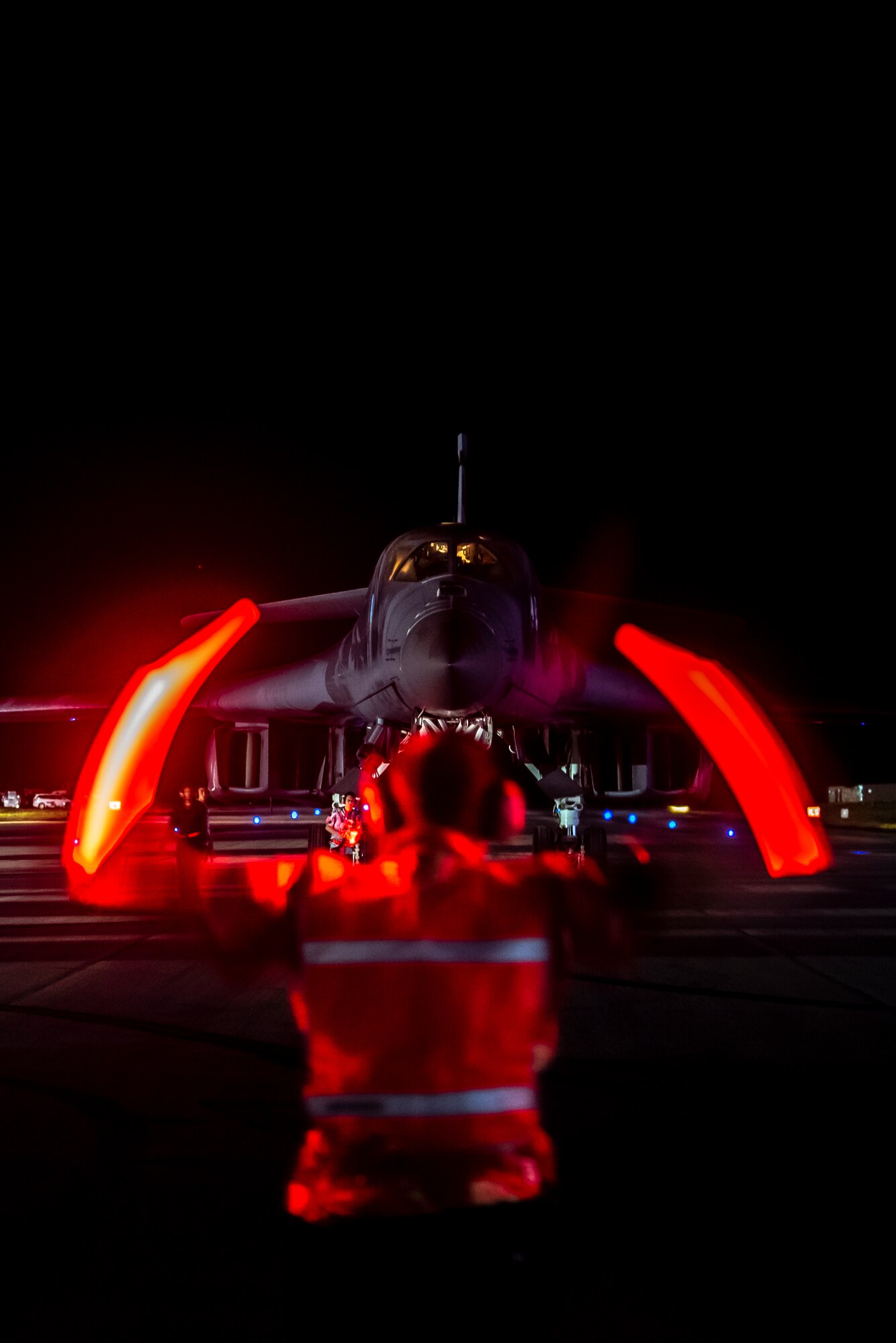 Photo of a United States Air Force service member marshaling a B-1B Lancer