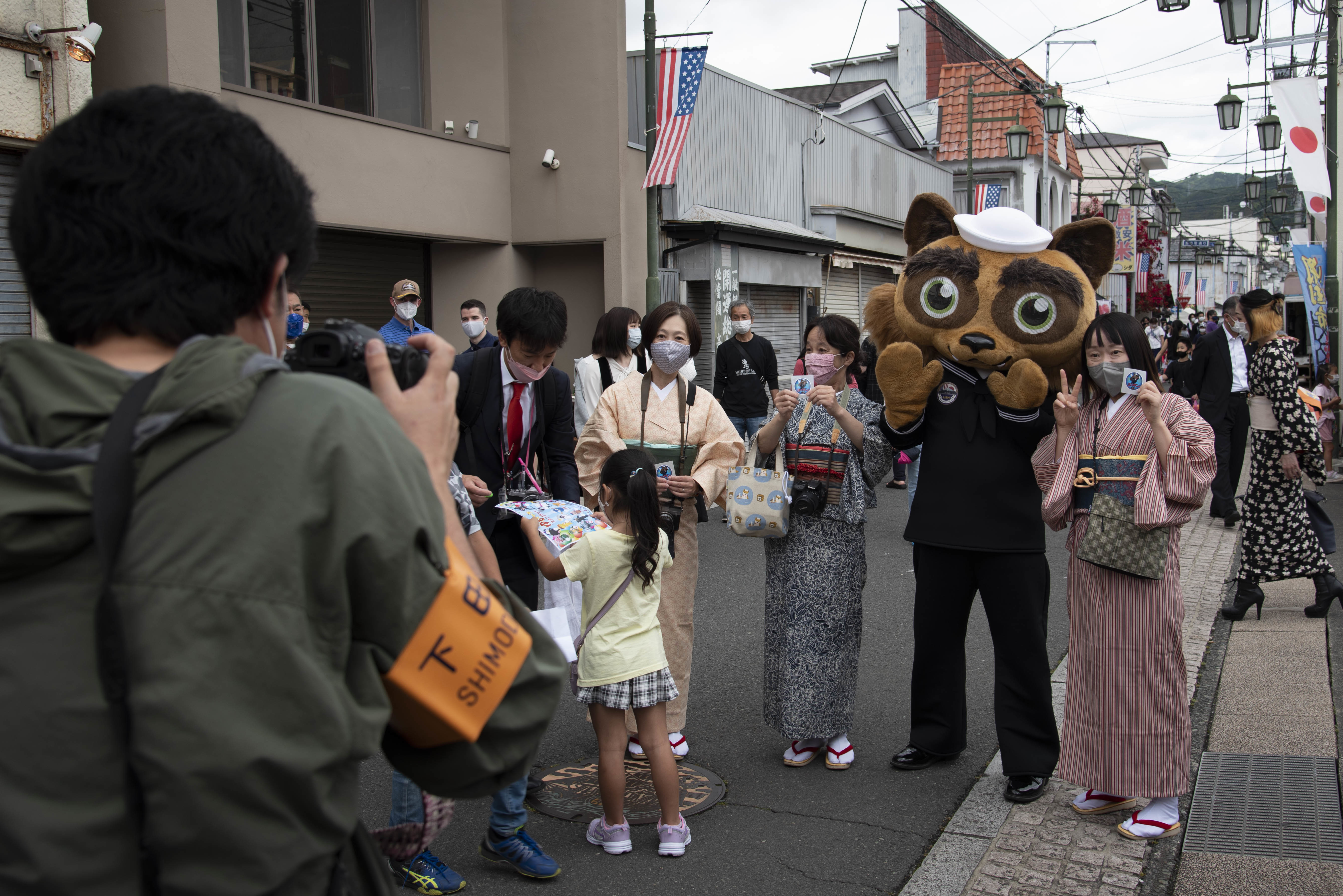 Yoko-pon, the official mascot of Commander, Fleet Activities Yokosuka (CFAY), poses for a photo with attendees of the 83rd annual Shimoda Black Ship festival.