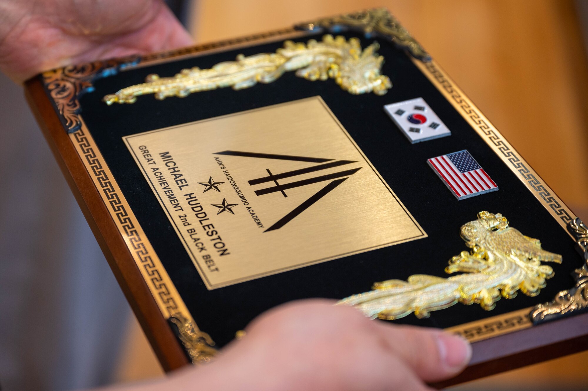 Sgt. 1st Class Michael Huddleston, 375th Ground Liaison Detachment non-commissioned officer in charge, is awarded a plaque for achieving his second degree black belt
