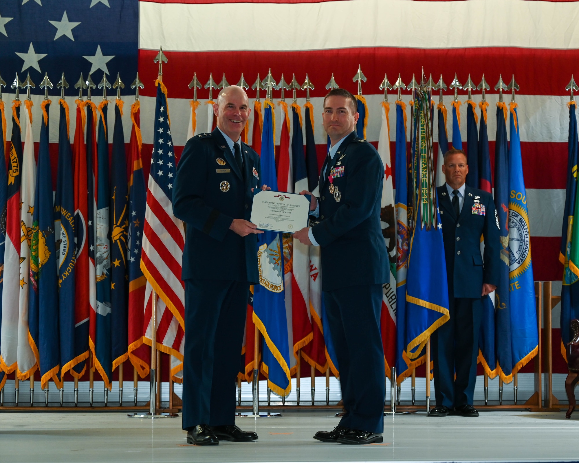 Maj. Gen. Michael Lutton, 20th Air Force commander, awards The Legion of Merit to Col. Christopher Menuey, former 91st Missile Wing commander, at Minot Air Force Base, North Dakota, June 06, 2022. The Legion of Merit is awarded tho those who have distinguished themselves by exceptionally meritorious conduct in the performance of outstanding services. (U.S. Air Force photo by Airman 1st Class Evan Lichtenhan)