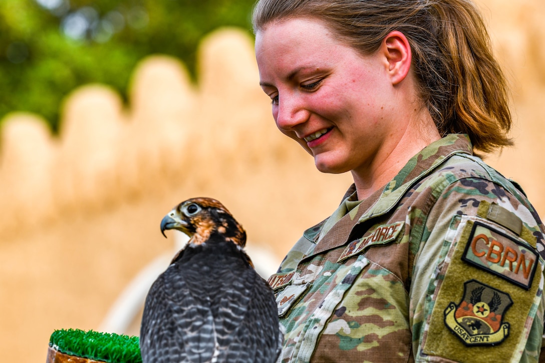 An airman holds a falcon.
