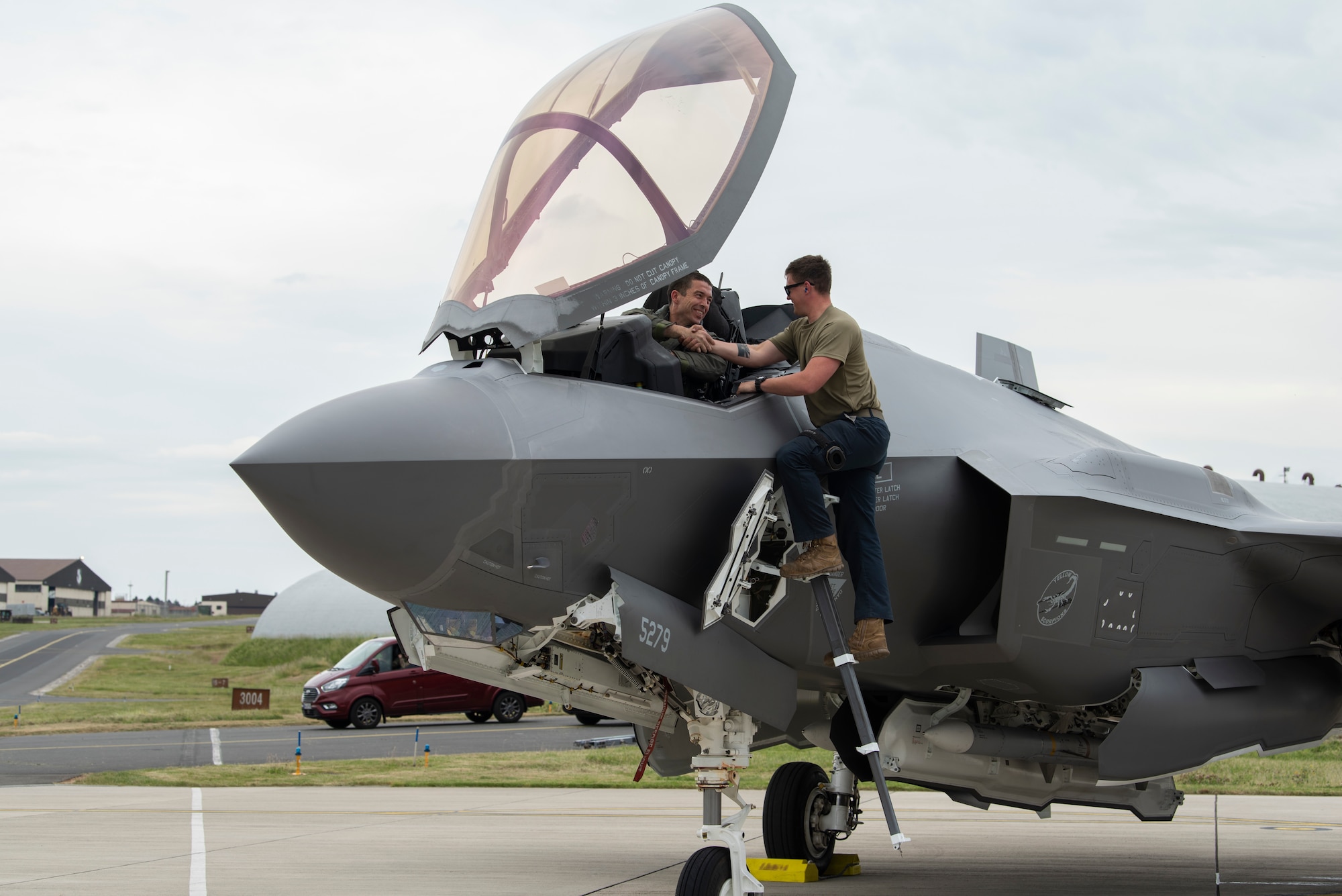 U.S. Air Force Senior Airman Cody Shepard, 315th Fighter Squadron crew chief, congratulates U.S. Air Force Lt. Col. Christopher White, 315th Fighter Squadron commander, after the pilot reached his 1,000th flight hour milestone in the F-35A Lightning II at Spangdahlem Air Base, Germany, June 3, 2022.  Airmen from the Vermont Air National Guard's 158th Fighter Wing are deployed to Europe to increase readiness and enhance NATO's collective defense. (U.S. Air Force photo by Tech. Sgt. Anthony Plyler)