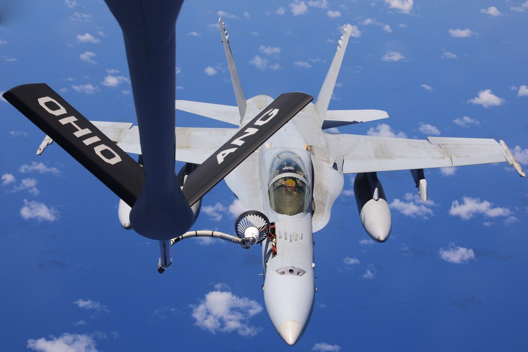 A military aircraft is refueled in midair.