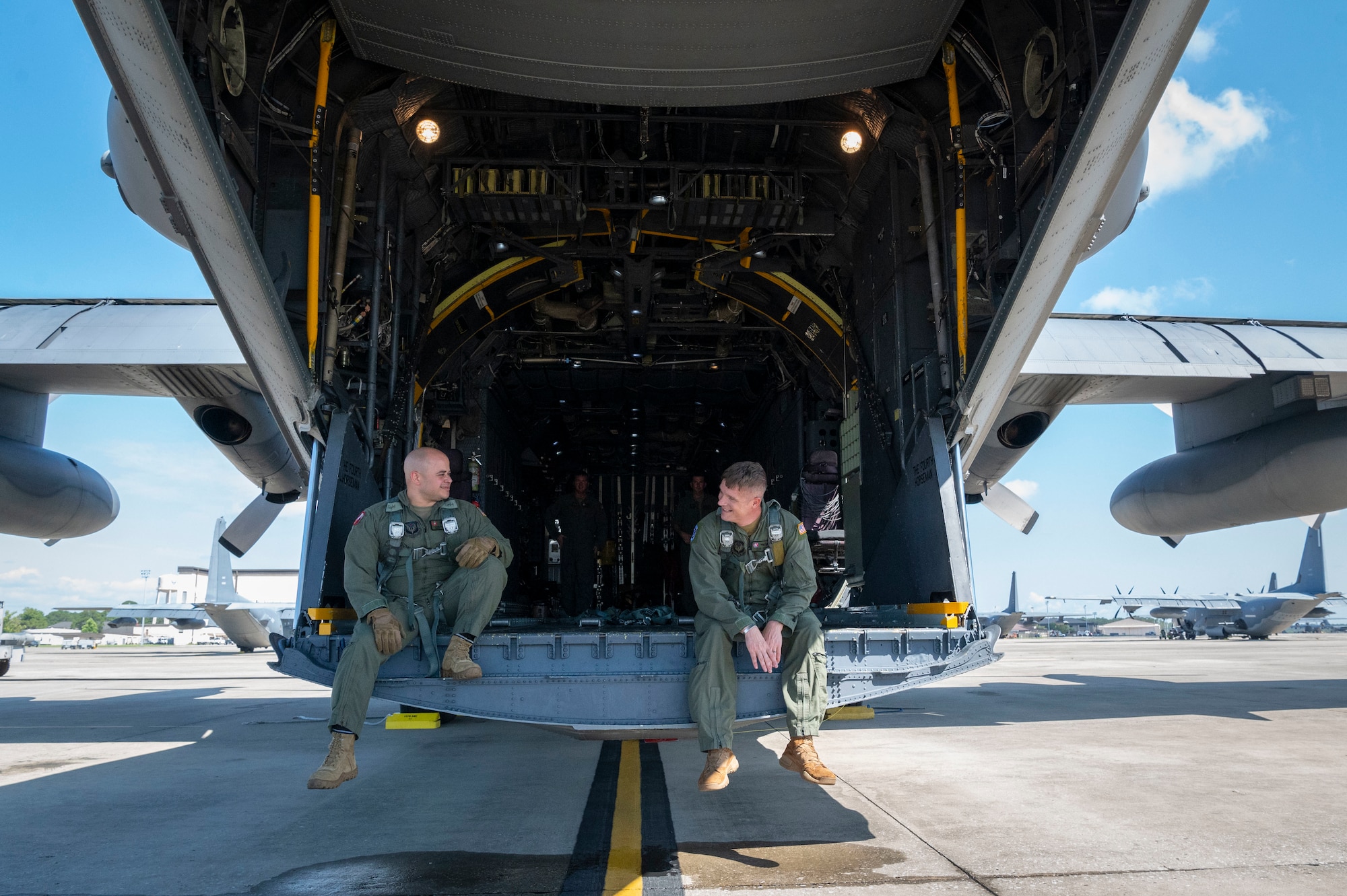 U.S. Air Force Master Sgt. Adrian Garcia, left, 19th Special Operations Squadron operations superintendent, and U.S. Air Force Master Sgt. Frank Veres, right, 492nd Special Operations Training Support Squadron MC-130H program manager, check harness lengths for the MC-130H Combat Talon II final flight under the 492nd Special Operations Wing at Hurlburt Field, Florida, May 31, 2022.