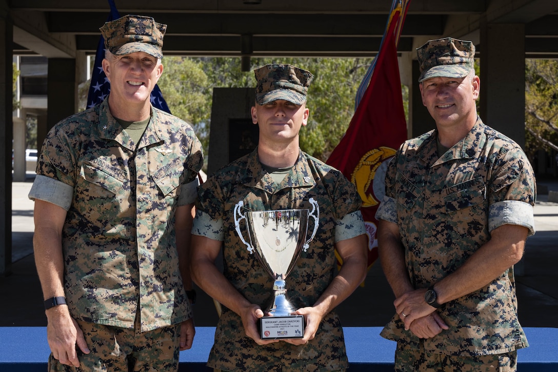 U.S. Marines Brig. Gen. Woodworth, the commanding general of Marine Corps Installations West, Marine Corps Base Camp Pendleton, Sgt. Zarzycki, the heavy equipment chief with Combat Logistics Battalion 13, Combat Logistics Regiment 17, 1st Marine Logistics Group, and Sgt. Maj. Matthew Hackett, the sergeant major of MCI-West, MCB Camp Pendleton, pose for a photo after the Camp Pendleton Male Marine Athlete of the Year award ceremony on Camp Pendleton, California, May 31, 2022. Zarzycki participated in the Ironman 70.3 World Championship and a 32.5-mile ultramarathon, and has completed smaller races, such as half marathons and various triathlons. (U.S. Marine Corps photo by Lance Cpl. Mhecaela J. Watts)