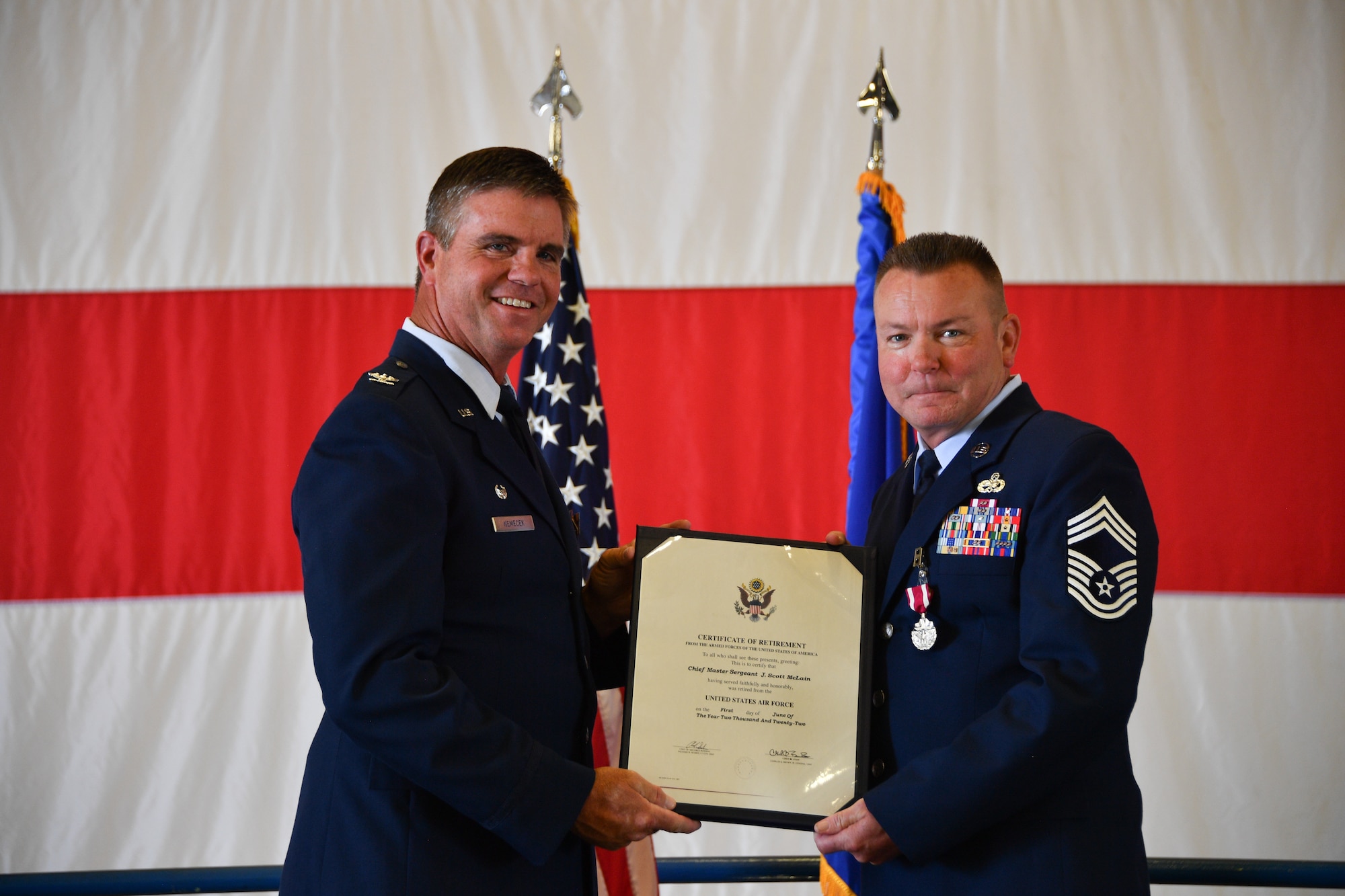 Chief Master Sgt. James S. Mclain, right, 301st Maintenance Squadron senior enlisted leader, receives the Certificate of Retirement from Col. John M. Nemecek, 301st Maintenance Group commander, during Mclains’s retirement ceremony at Naval Air Station Joint Reserve Base Fort Worth, Texas, June 4, 2022. Mclain  honorably served for 27 years. (U.S. Air Force photo by Staff Sgt. Nije Hightower)