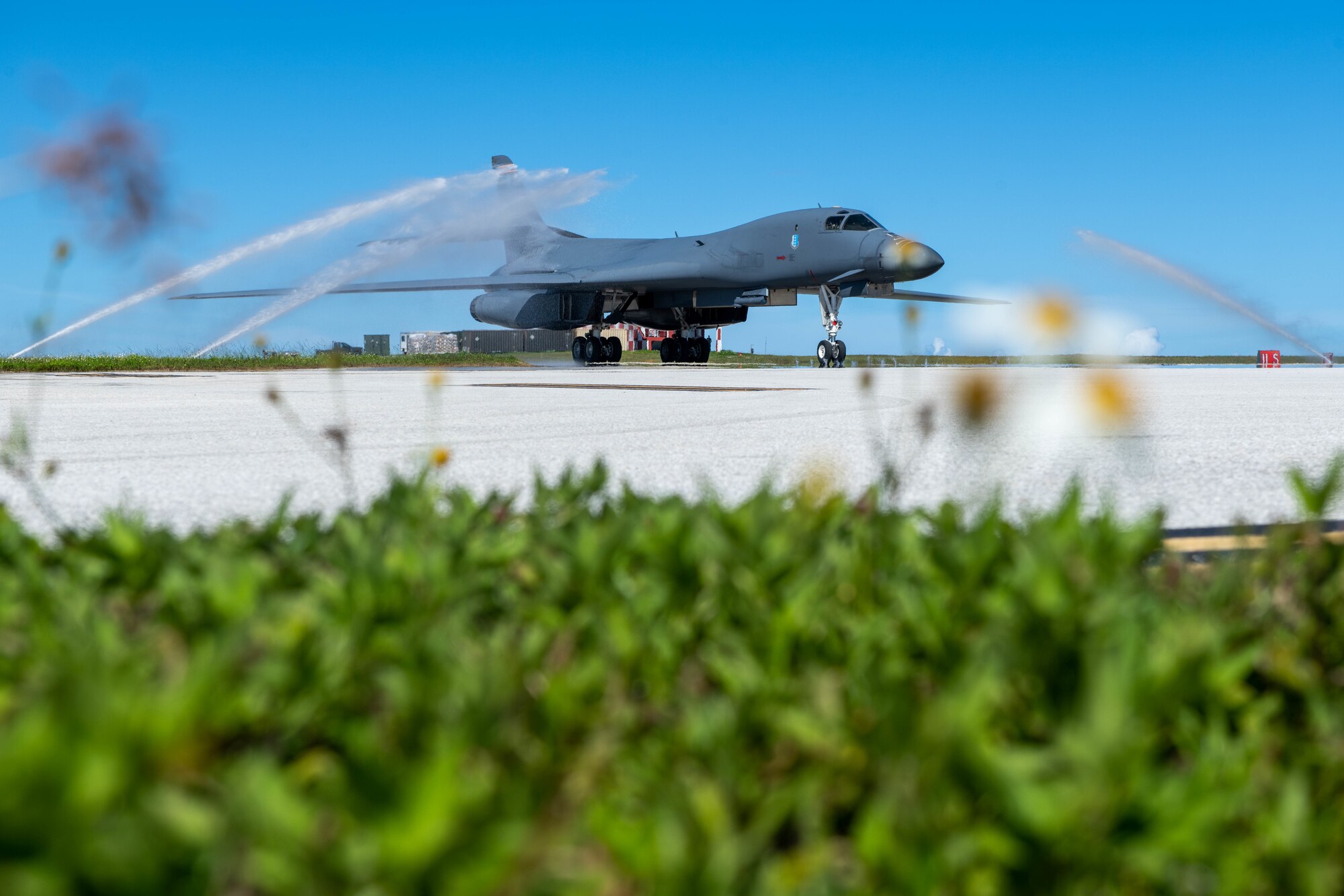A U.S. Air Force B-1B Lancer, assigned to the 34th Bomb Squadron, Ellsworth Air Force Base, taxis through a clean water wash station at Andersen Air Force Base, Guam, after arriving for a Bomber Task Force mission June 2, 2022.
