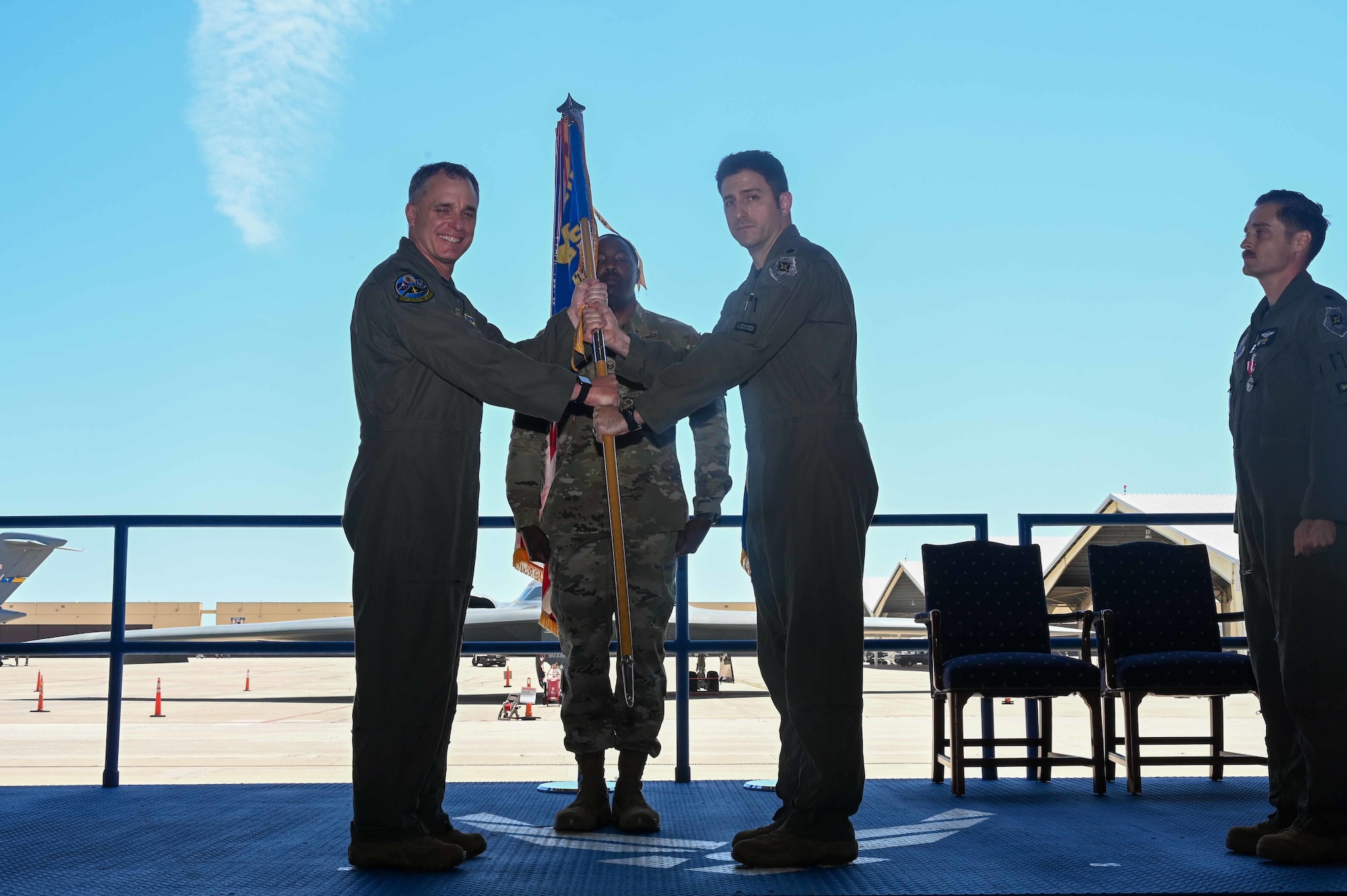 U.S. Air Force Col. Keith Butler, 509th Operation Group commander, passes the unit flag to U.S. Air Force Lt. Col. Andrew Kousgaard, incoming 393rd Bomb Squadron commander, during the 393rd Bomb Squadron change of command ceremony at Whiteman Air Force Base, MO, June 3, 2022. Military change-of-commands are a time-honored tradition that formally symbolize the continuity of authority as the command passes from one individual to another. The transfer of command is physically represented by handing the unit flag, from the outgoing commander to the new incoming commander. (U.S. Air Force photo by Airman 1st Class Devan Halstead)