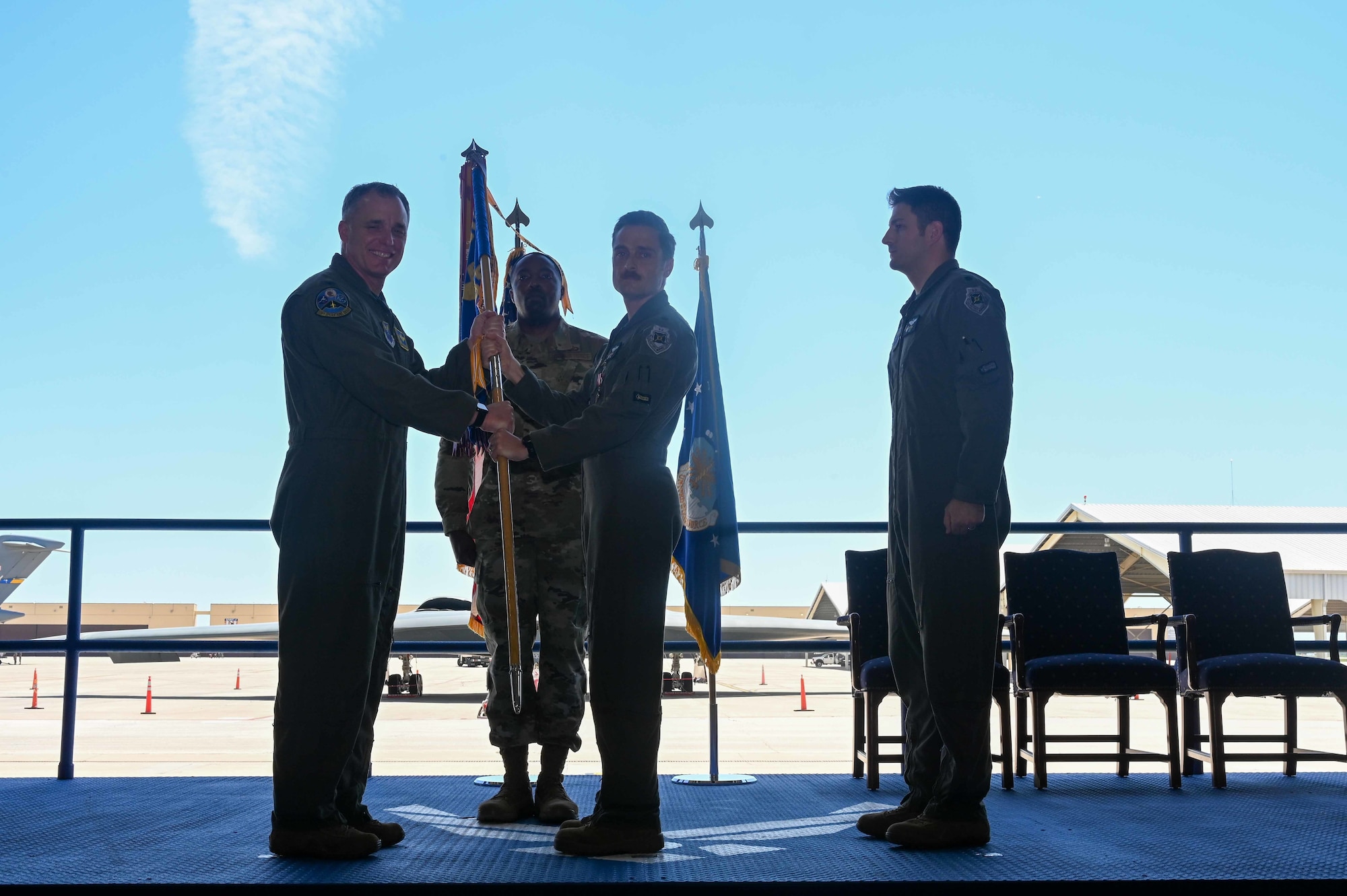 U.S. Air Force Lt. Col. Christopher Conant, outgoing 393rd Bomb Squadron commander, passes the unit flag to U.S. Air Force Col. Keith Butler, 509th Operations Group commander, during the 393rd Bomb Squadron change of command ceremony at Whiteman Air Force Base, MO, June 3 2022. This act symbolizes Conant relinquishing command of the 393rd Bomb Squadron to U.S. Air Force Lt. Col. Andrew Kousgaard, incoming 393rd Bomb Squadron commander. (U.S. Air Force photo by Airman 1st Class Devan Halstead)