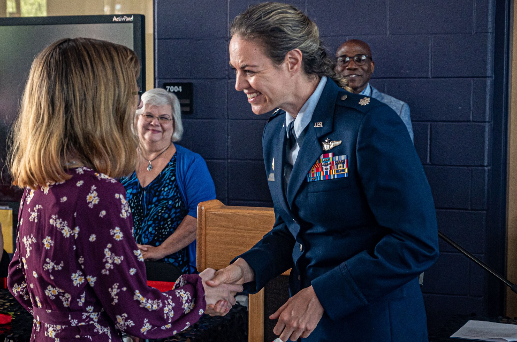 A photo of a U.S. Air Force member shaking hands with someone.
