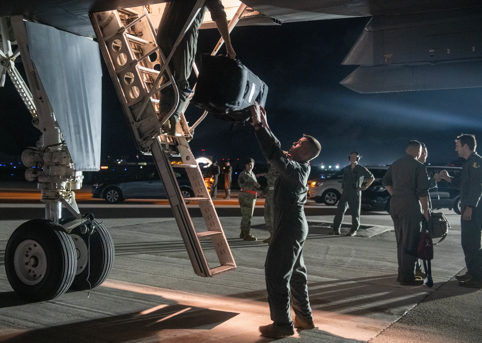U.S. Air Force personnel assigned to the 34th Bomb Squadron, Ellsworth Air Force Base, unload bags from a B-1B Lancer on Andersen Air Force Base, Guam, after arriving for a Bomber Task Force mission June 3, 2022.
