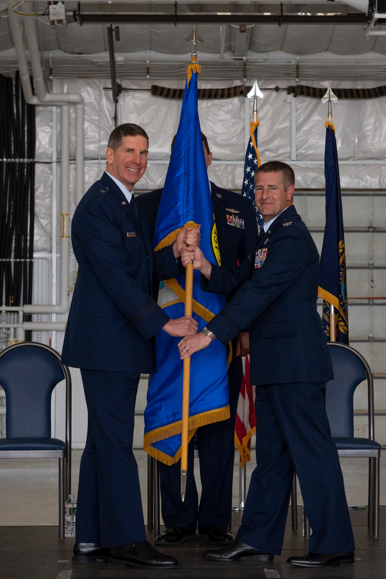 Brig. Gen. Jed French, commander of the New Hampshire Air National Guard, passes the 157th Air Refueling Wing guidon to Col. Nelson Perron during a ceremony June 4, 2022, at Pease Air National Guard Base, New Hampshire. Perron officially assumed command of the wing during the ceremony. (U.S. Air National Guard photo by Staff Sgt. Taylor Queen)