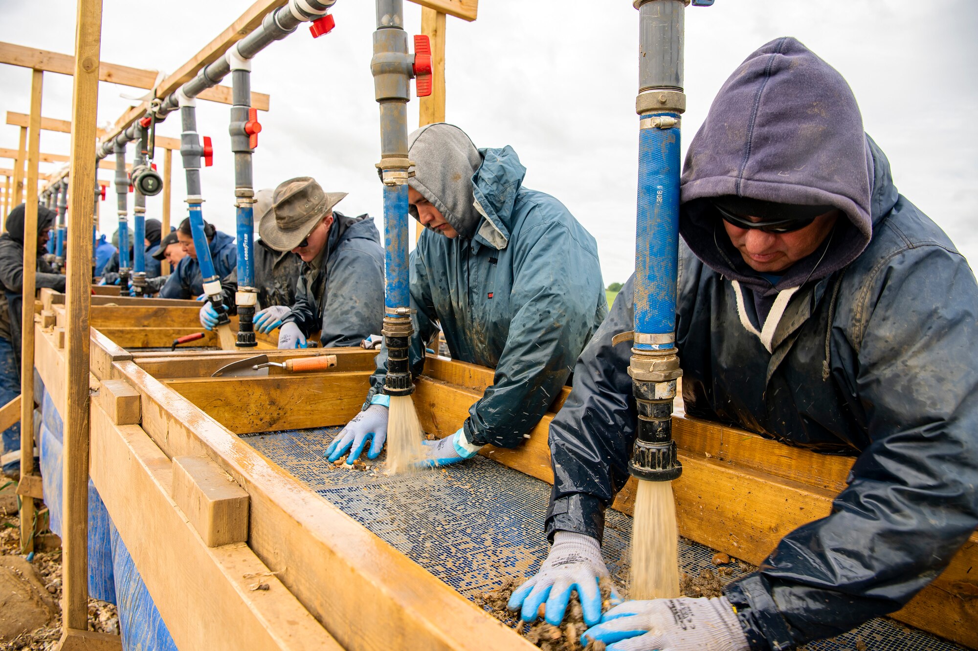 POW/MIA Accounting Agency members, as well as volunteers from bases in England, sift through dirt near London-Stansted, England, May 25, 2022. The team was conducting a recovery operation for the remains of a U.S. service member whose plane crashed there in 1944 during World War II. (U.S. Air Force photo by Staff Sgt. Eugene Oliver)