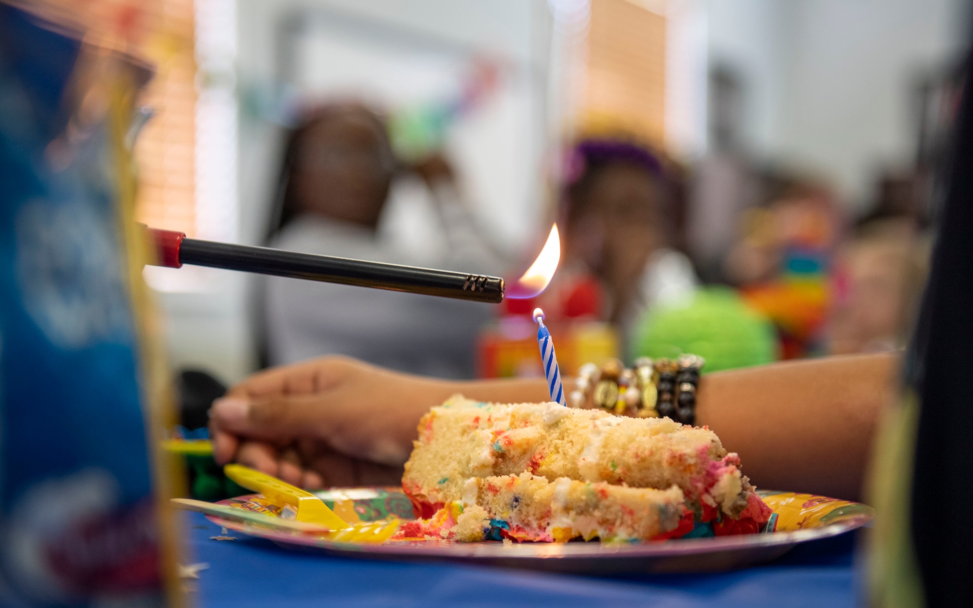 A candle is lit on a piece of cake to celebrate the birthdays of children in foster care at the New Life Village campus located in Tampa, Florida, May 29, 2022. This month, 10 service members, assigned to MacDill Air Force Base, joined the fun, celebrating with party games, a piñata and cake. (U.S. Air Force photo by Airman 1st Class Lauren Cobin)