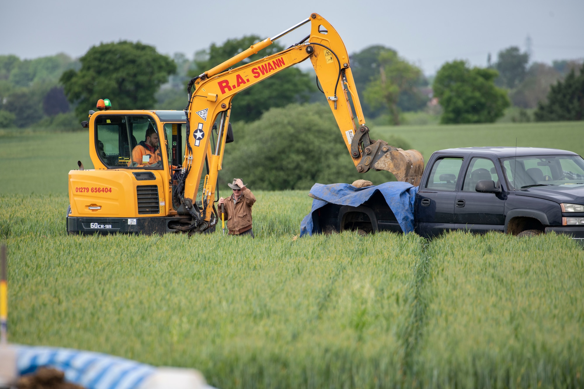 A POW/MIA Accounting Agency member operates an excavator near London-Stansted, England, May 25, 2022. POW/MIA Accounting Agency members, as well as volunteers from bases in England, were conducting a recovery operation for the remains of a U.S. service member whose plane crashed there in 1944. (U.S. Air Force photo by Senior Airman Jason W. Cochran)