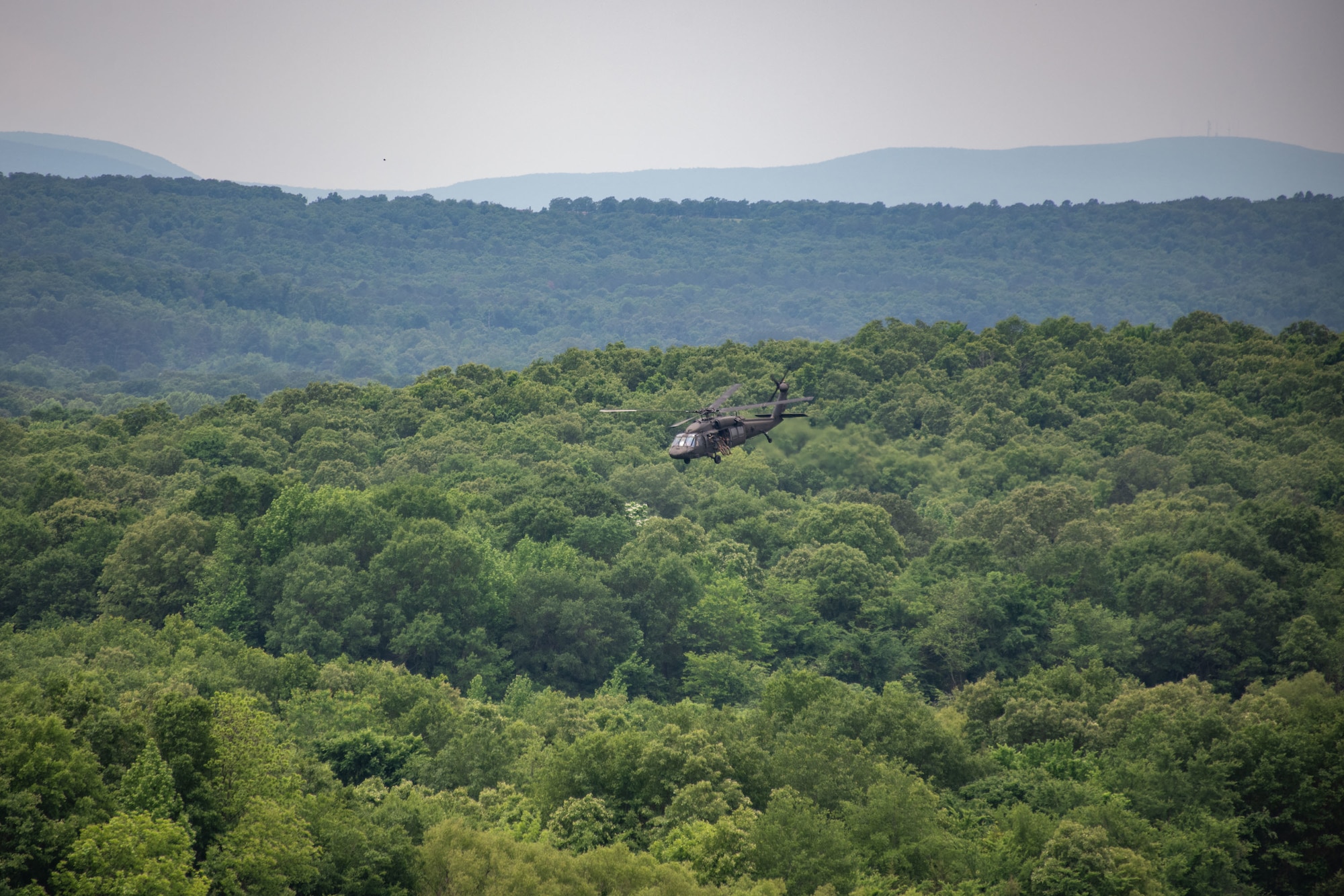 helicopter flies over mountains