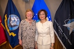 two civilian women pose in front of flags