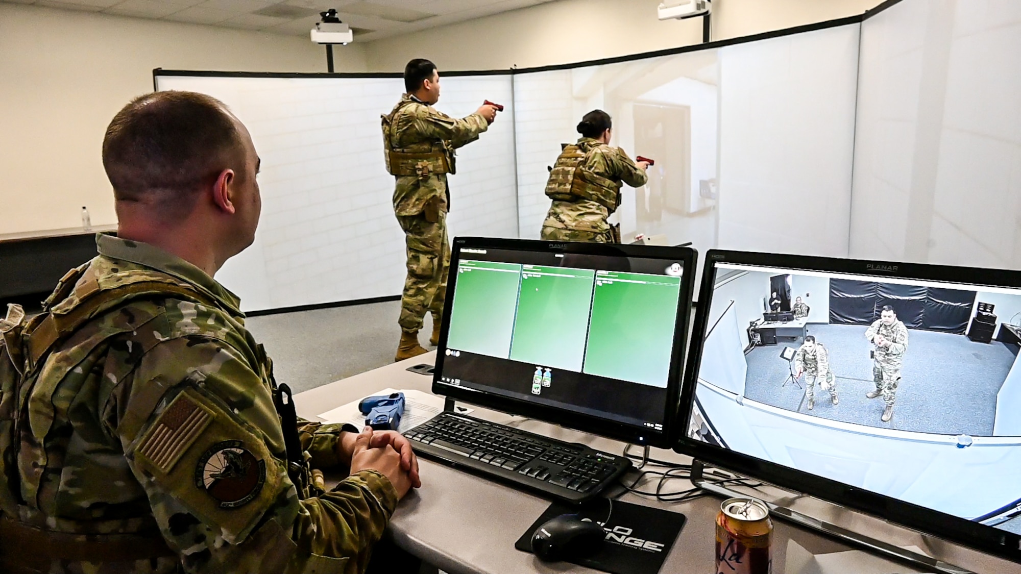 Staff Sgt. Charles Spellman, 412th Security Forces Squadron Standardization and Evaluations, monitors two Defenders as they go through a training scenario on the Multiple Interactive Learning Objectives (MILO) simulator at the Combat Arms Training and Maintenance (CATM) center on Edwards Air Force Base, California. (Air Force photo by Katherine Franco)