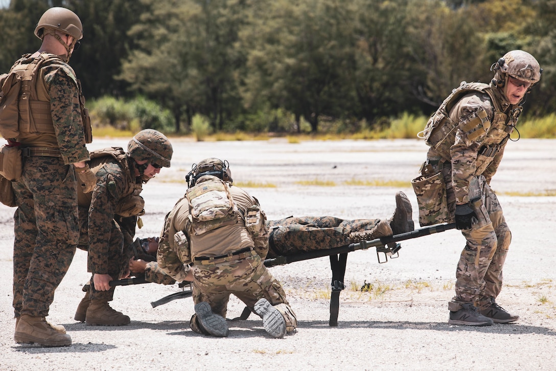 U.S. Marines with Marine Wing Support Squadron 171, 1st Marine Air Wing and sailors with Explosive Ordnance Disposal Mobile Unit Five, carry a simulated casualty during Valiant Shield 2022 at Andersen Air Force Base, Guam, June 7, 2022. The training focused on the rapid clearing of unexploded ordnance in response to a simulated airfield attack allowing for safe airfield repair and continued operations.