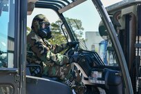 U.S. Air Force Airman 1st Class Jaron Stamper, 628th Logistics Readiness Squadron Individual Protective Equipment journeyman, receives instruction on how to pick up a container during forklift training at Joint Base Charleston, South Carolina, June 2, 2022.