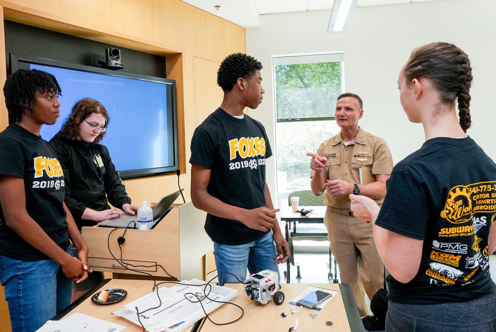IMAGE: Vice Adm. William Galinis speaks with one of the robotics teams from King George High school as they ready their robot for competition. Galinis served as the featured speaker for the event.