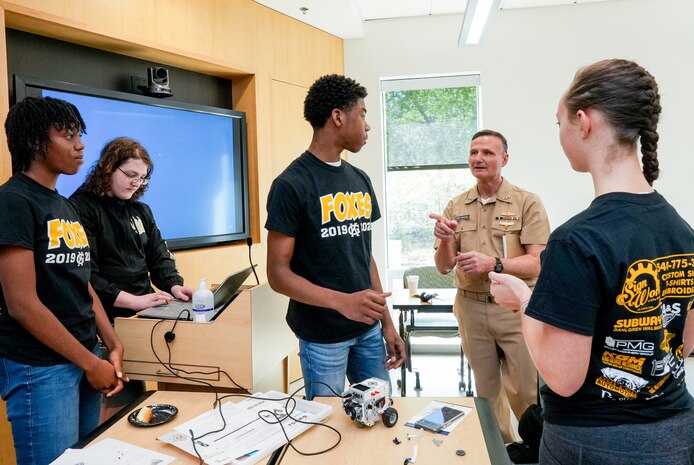 IMAGE: Vice Adm. William Galinis speaks with one of the robotics teams from King George High school as they ready their robot for competition. Galinis served as the featured speaker for the event.