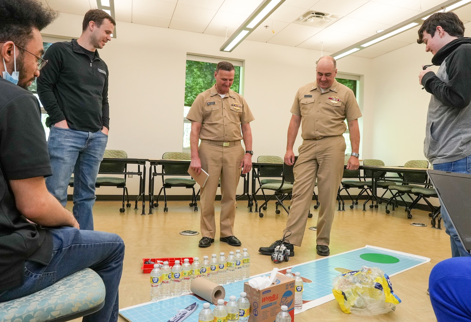 IMAGE: Vice Adm. William Galinis watches as Naval Surface Warfare Center Dahlgren Division Commanding Officer Capt. Philip “Phil” Mlynarski stops Bridging Communities Governor’s School’s wayward robot. Galinis and Mlynarski met with the students prior to the start of competition at the Innovation Challenge @Dahlgren.