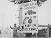 In this undated photo, a U.S. Army Soldier poses next to a sign indicating the Red Ball Express route. The 82-day operation was a critical logistics effort during WW II to supply the First and Third Armies as they advanced across France.  At its peak, the Red Ball Express delivered 12,500 tons of supplies per day.