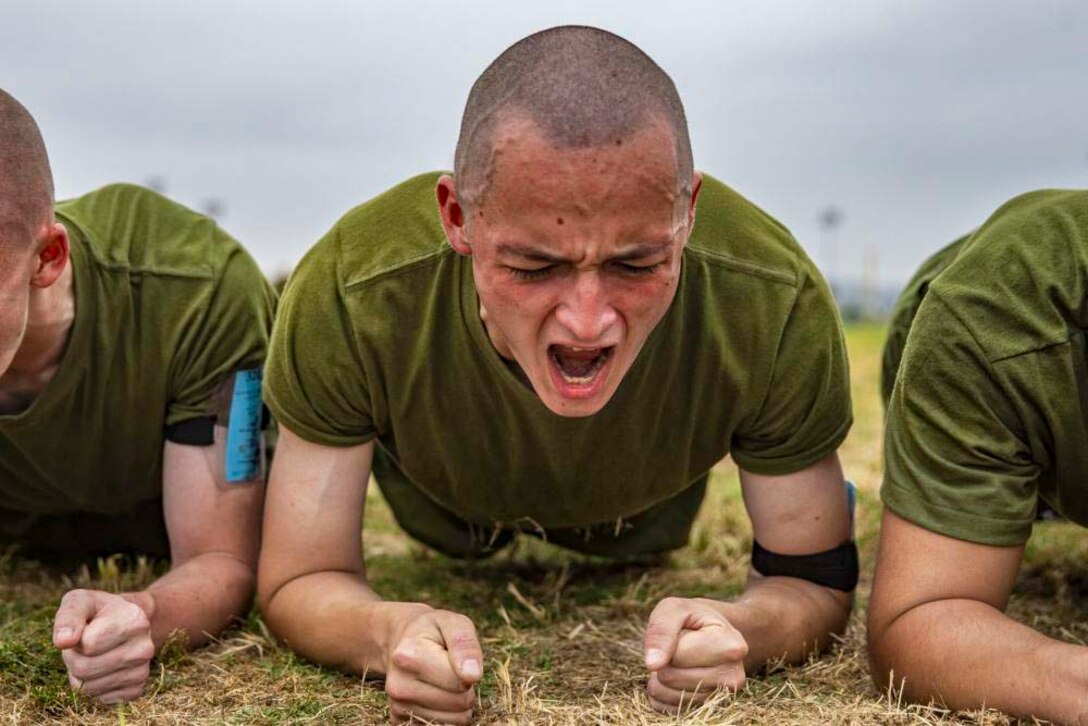 A Marine Corps recruit holds a plank position.
